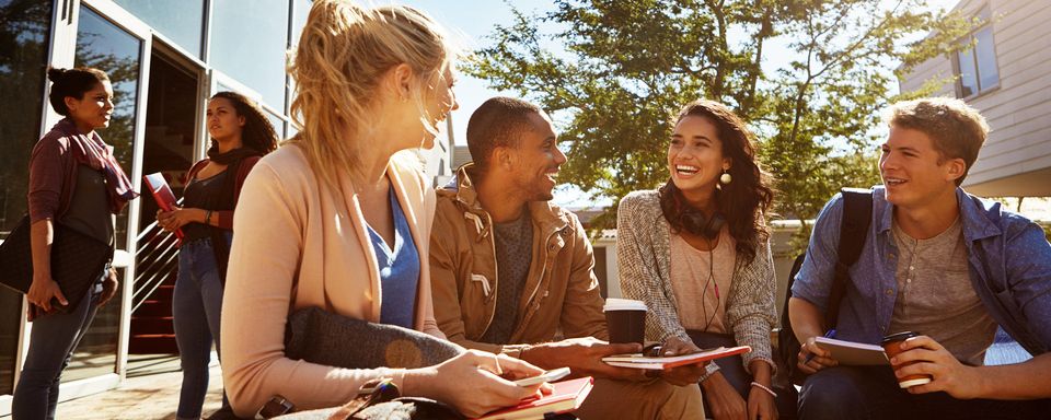 Bande de jeunes dehors en train de rire sur le campus